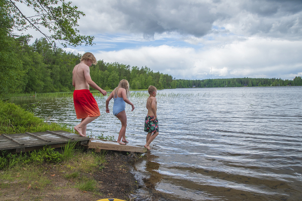 Lapset astumassa veteen Ruostejärven saunalla.