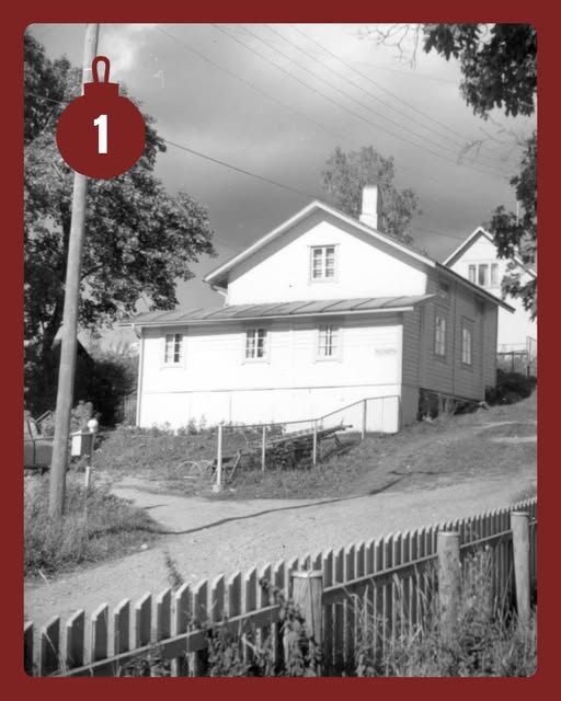 Mustavalkoinen vanha valokuva omakotitalosta. Kuvan koristeena punainen joulupallo, jossa numero yksi.