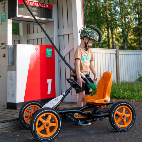 Lapsi tankkaamassa polkuautoaan liikennepuistossa.