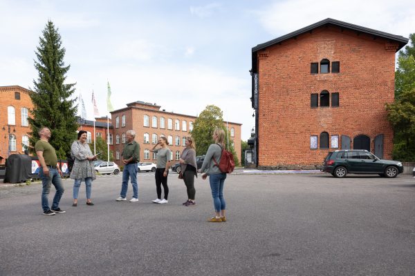 Matkaopas ryhmänsä kanssa Forssan punatiilisellä kehräämöalueella.